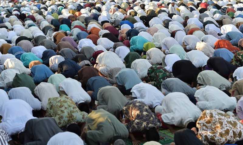 Indonesian muslim people perform Eid al-Adha prayers on a road at Jatinegara of Jakarta, in Indonesia, on July 10, 2022.Photo:Xinhua