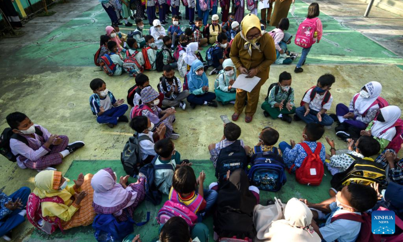 A faculty member organizes a game for the students during the first-day orientation of school year 2022-2023 at Jombang elementary school in South Tangerang of Banten Province, Indonesia, July 11, 2022. (Xinhua/Agung Kuncahya B.)