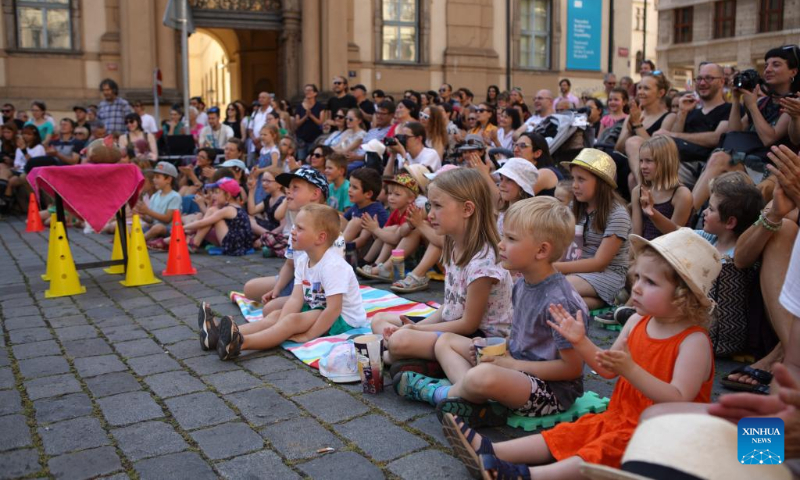 People watch a performance during the 14th Prague Street Theater Festival in Prague, the Czech Republic, July 19, 2022. The week-long festival, which saw more than 40 performances by artists from several countries, closed Tuesday in the Czech capital. (Photo by Dana Kesnerova/Xinhua)