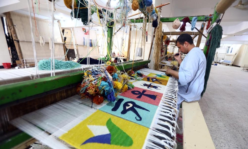 A man weaves a carpet at a weaving workshop at Saqqara village in Giza, Egypt, July 2, 2022.Photo:Xinhua
