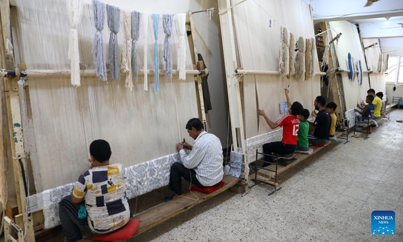 People weave a carpet at a weaving workshop at Saqqara village in Giza, Egypt, July 2, 2022.Photo:Xinhua