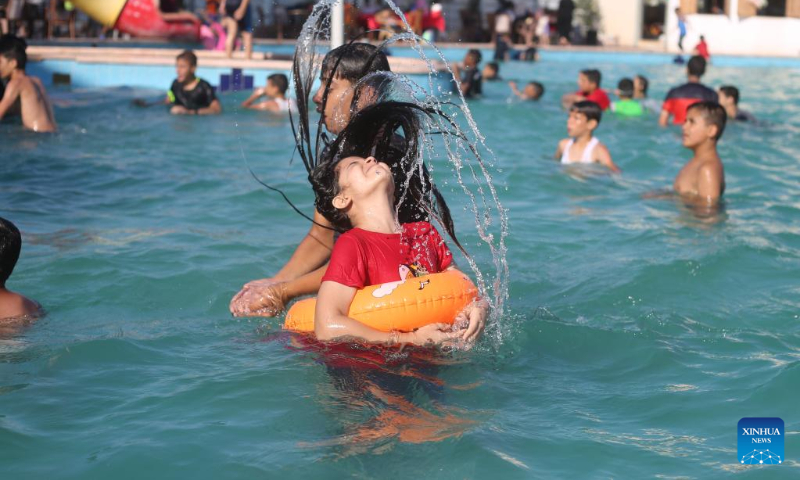 Children play in a pool to cool off during a hot day in the southern Gaza Strip city of Rafah, on July 16, 2022. (Photo by Khaled Omar/Xinhua)