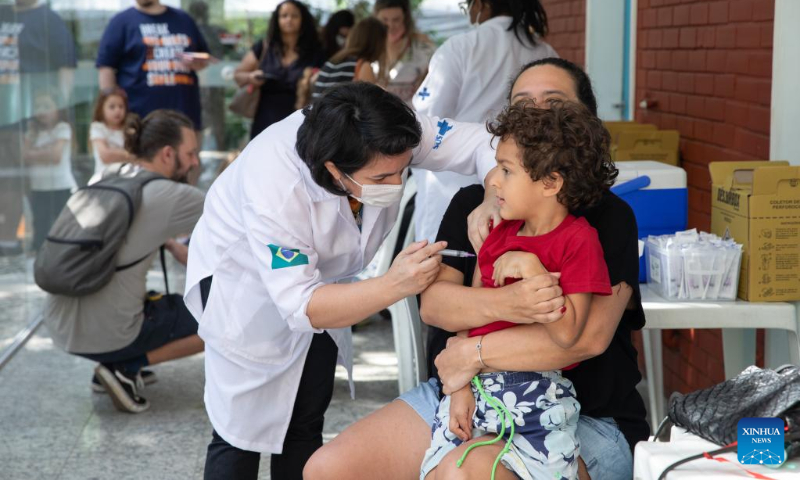 A medical worker administers a dose of CoronaVac vaccine developed by Chinese laboratory Sinovac to a boy at a vaccination site in Rio De Janeiro, Brazil, on July 16, 2022. (Xinhua/Wang Tiancong)