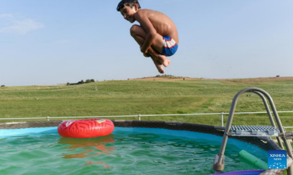 A child jumps into a pool in Caceres, Spain, July 13, 2022. Eighty-four people are known to have died from the heat wave that has struck Spain since July 10, the Carlos III Health Institute, which reports to the Spanish Ministry of Health, said on Friday. Photo:Xinhua