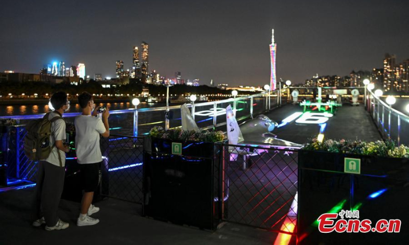 Tourists enjoy the night view along the Pearl River on the Blue Dolphin 16 cruise ship in Guangzhou, south China's Guangdong Province, July 12, 2022. (Photo: China News Service/Chen Jimin)