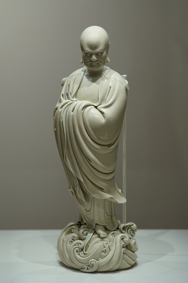 A man practices calligraphy on a screen at HKPM on July 3, 2022. 
Right: Standing Bodhidharma from the Dehua Kiln 
Top: HKPM Photos: IC