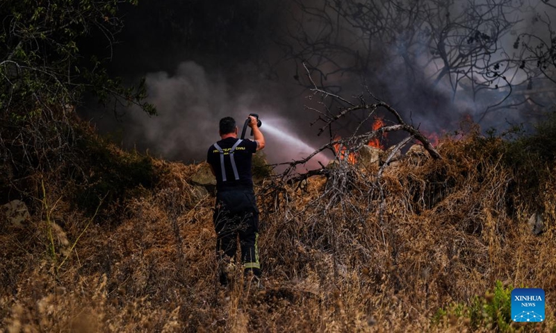 A firefighter battles a wildfire in Iklin, a small town in central Malta, on July 10, 2022.Photo:Xinhua