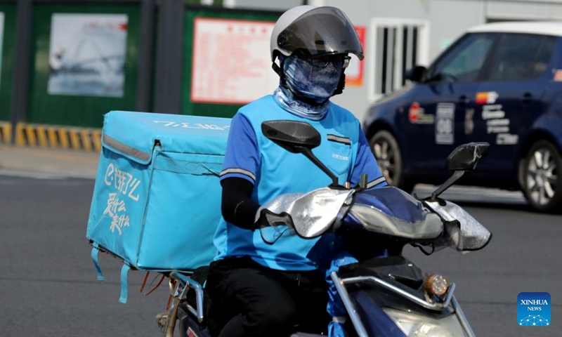 A deliveryman is seen on the street amid high temperature in Minhang District of east China's Shanghai, July 10, 2022.Photo:Xinhua