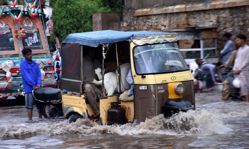 Vehicles move on a flooded road after heavy rain in southern Pakistani port city of Karachi on July 9, 2022.Photo:Xinhua