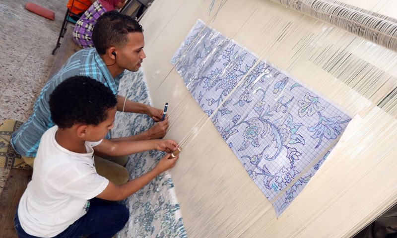 People weave a carpet at a weaving workshop at Saqqara village in Giza, Egypt, July 2, 2022.Photo:Xinhua