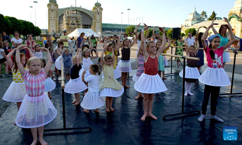 Children learn ballet at a workshop during the 14th Prague Street Theater Festival in Prague, the Czech Republic, July 19, 2022. The week-long festival, which saw more than 40 performances by artists from several countries, closed Tuesday in the Czech capital. (Photo by Dana Kesnerova/Xinhua)