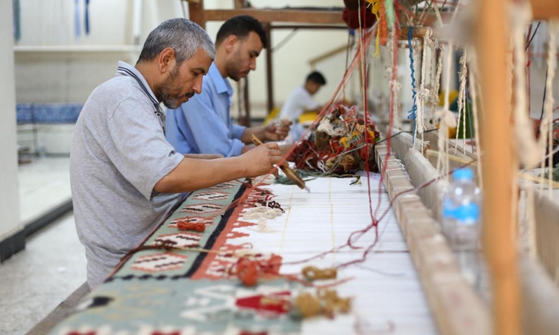 People weave a carpet at a weaving workshop at Saqqara village in Giza, Egypt, July 2, 2022.Photo:Xinhua