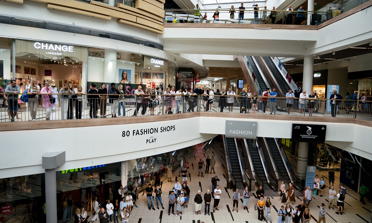 people observe a minutes silence at the fields shopping center