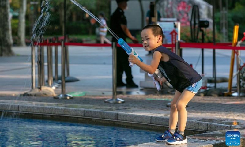 A child plays with a toy water gun amid high temperature at a park in Xuhui District of east China's Shanghai, July 10, 2022.Photo:Xinhua