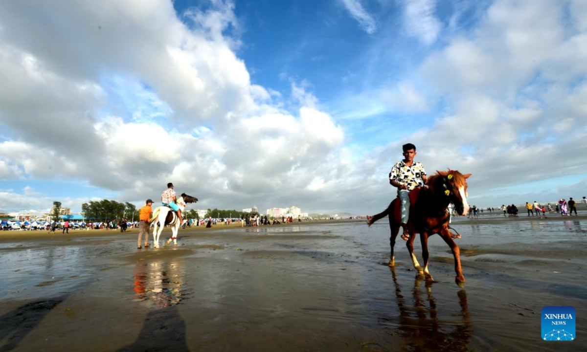 People enjoy horse riding at a beach during Eid al-Adha holiday in Cox's Bazar, Bangladesh, July 12, 2022. Photo:Xinhua
