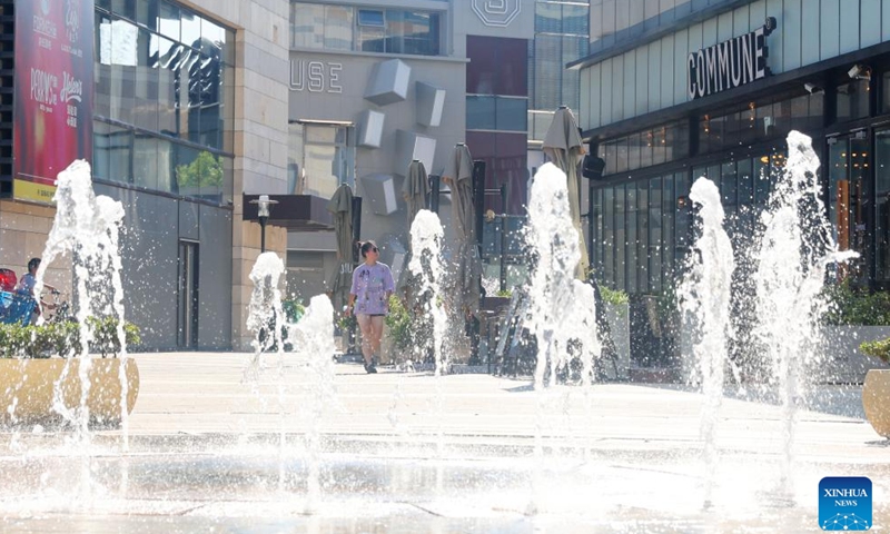 A citizen walks by a fountain amid high temperature in Minhang District of east China's Shanghai, July 10, 2022.Photo:Xinhua