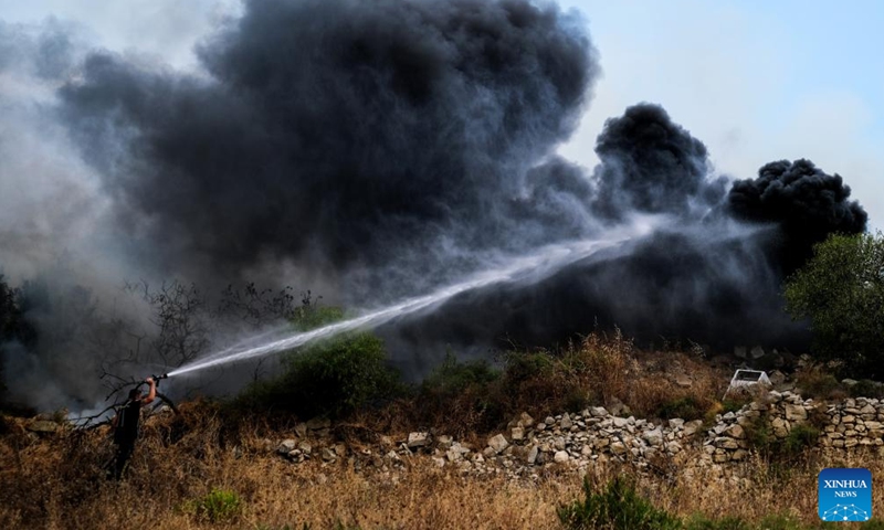 A firefighter battles a wildfire in Iklin, a small town in central Malta, on July 10, 2022.Photo:Xinhua