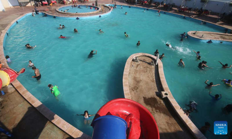 People swim in a pool to cool off during a hot day in the southern Gaza Strip city of Rafah, on July 16, 2022. (Photo by Khaled Omar/Xinhua)