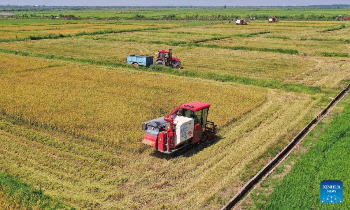 Aerial photo shows agricultural vehicles harvesting early-season rice in Nanchang County, east China's Jiangxi Province, July 13, 2022. Photo:Xinhua