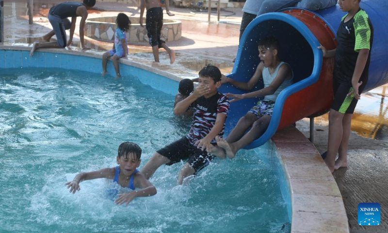 Children play in a pool to cool off during a hot day in the southern Gaza Strip city of Rafah, on July 16, 2022. (Photo by Khaled Omar/Xinhua)
