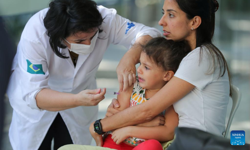 A medical worker administers a dose of CoronaVac vaccine developed by Chinese laboratory Sinovac to a girl at a vaccination site in Rio De Janeiro, Brazil, on July 16, 2022. (Xinhua/Wang Tiancong)