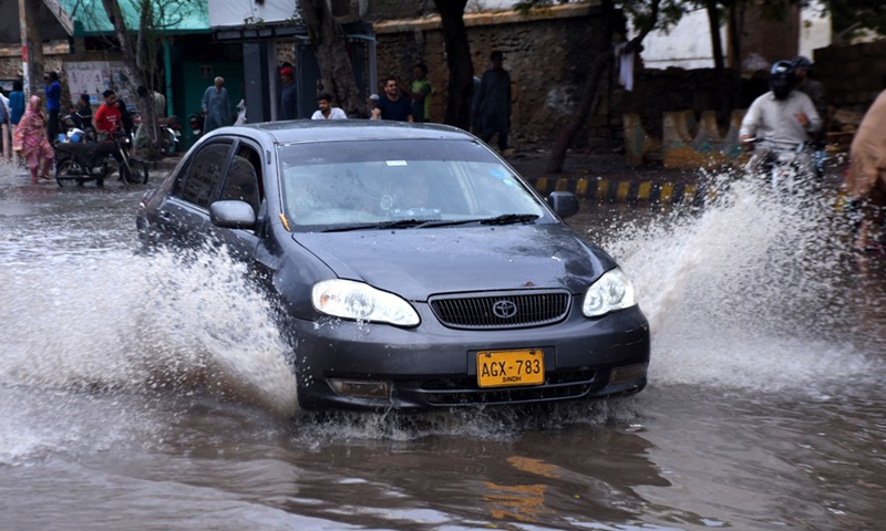 A car moves on a flooded road after heavy rain in southern Pakistani port city of Karachi on July 9, 2022.Photo:Xinhua