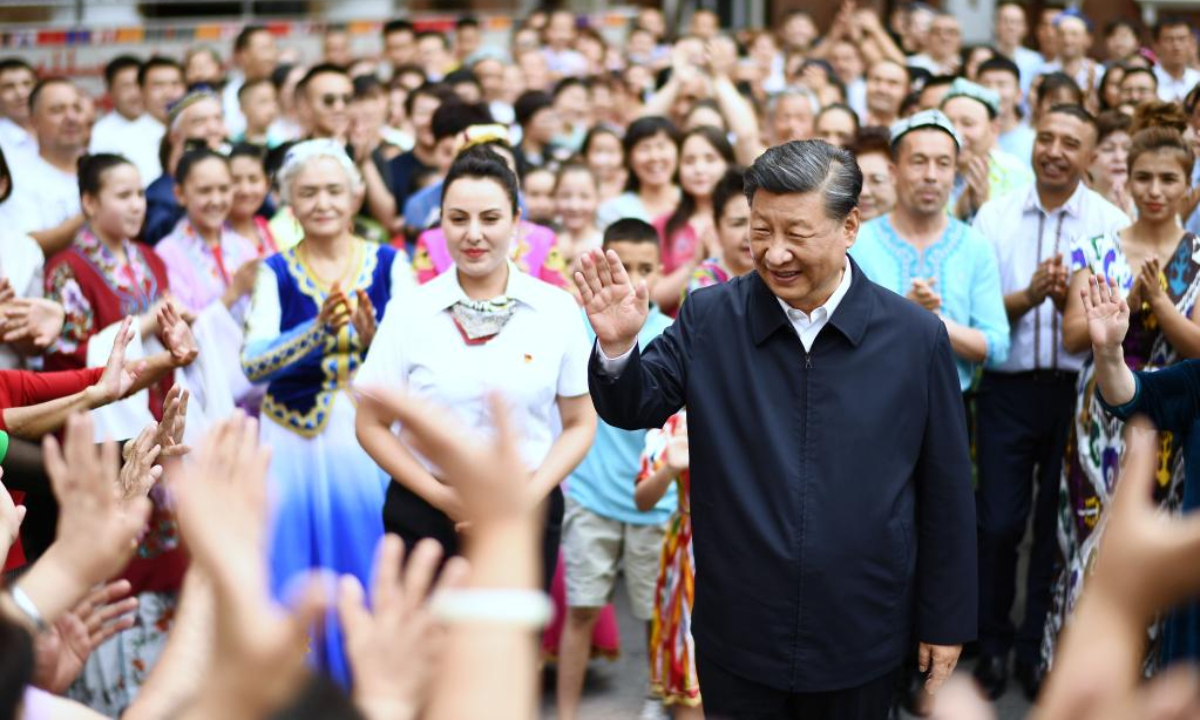 Chinese President Xi Jinping, also general secretary of the Communist Party of China Central Committee and chairman of the Central Military Commission, waves to people of various ethnic groups while visiting the community of Guyuanxiang in the Tianshan District in the city of Urumqi, capital of northwest China's Xinjiang Uygur Autonomous Region, July 13, 2022. Photo:Xinhua