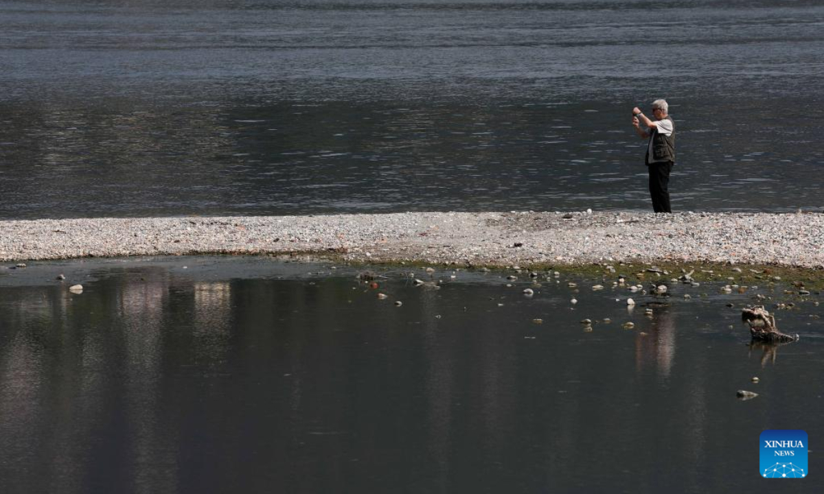A man takes photos at Lake Como in Como, Lombardy region, Italy, on July 13, 2022. Photo:Xinhua