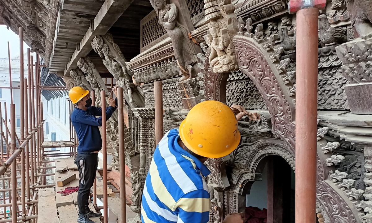 Experts work to restore the carved wooden walls of the Basantapur Palace complex. Photo: Courtesy of the CACH