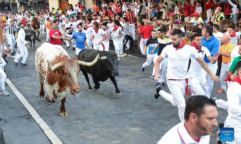 People take part in the traditional running of the bulls during the San Fermin Festival in Pamplona, Spain, on July 11, 2022. The festival started on July 6 and will last till July 14.(Photo: Xinhua)