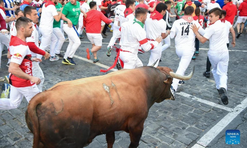 People take part in the traditional running of the bulls during the San Fermin Festival in Pamplona, Spain, on July 11, 2022. The festival started on July 6 and will last till July 14.(Photo: Xinhua)