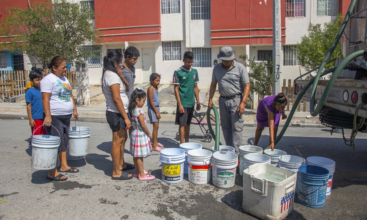 Residents queue to collect drinkable water from a tanker truck in Garcia, Mexico, on July 5, 2022. Photo: AFP