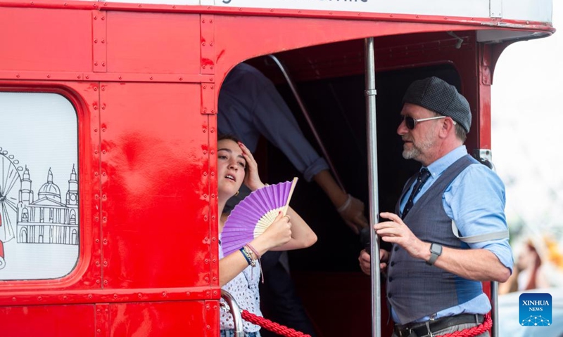 A woman uses a fan to keep cool on a bus on Westminster Bridge in London, Britain, July 11, 2022. London is currently experiencing a heatwave as temperature hit a high of 32 degrees Celsius in west London on Monday.(Photo: Xinhua)