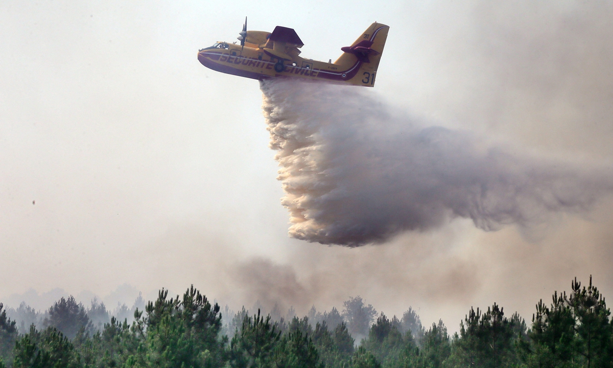A Canadair firefighting aircraft dumps water over a wildfire in Landiras, southwestern France, on July 13, 2022. A heat wave in Western Europe is fuelling wildfires across vast stretches of forestland. Photo: AFP