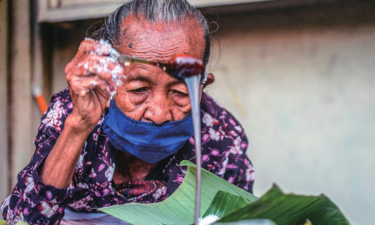 76-year-old snack vendor Mbah Satinem makes her popular dish.Photo: VCG
