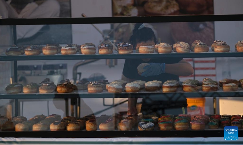 An employee organizes donuts at the Malta International Food Festival in Valletta, Malta, on July 13, 2022.(Photo: Xinhua)