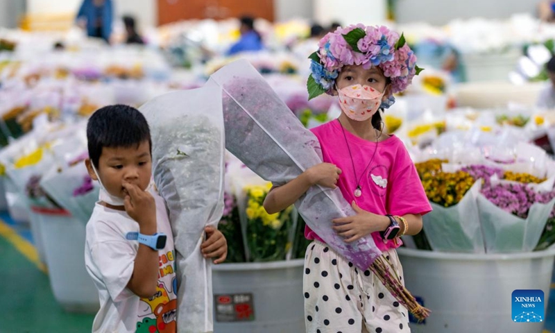 Children visit Kunming Dounan Flower Market at night in southwest China's Yunnan Province, July 12, 2022. Representing China's largest fresh-cut flower market in terms of trading volume and of export value for 23 consecutive years, Dounan has become the largest fresh cut flower trading market in Asia.  In recent years, the market has vigorously developed the night economy with flower consumption, tourism and cultural experience.  (Photo: Xinhua)