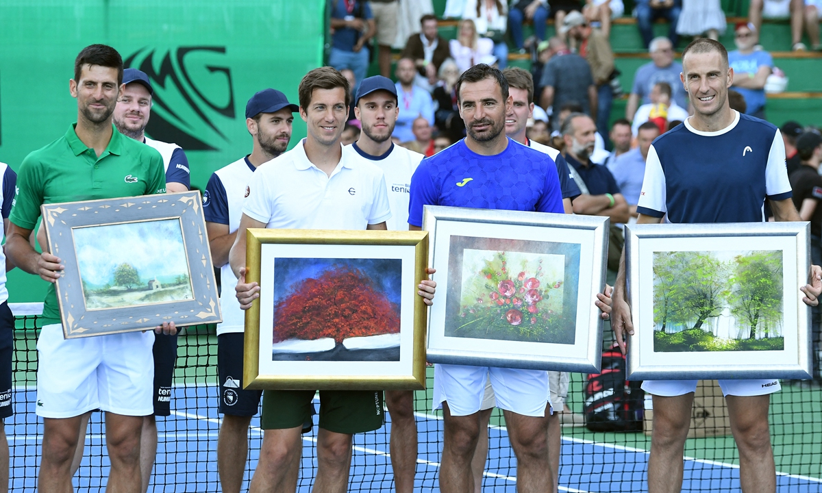 Tennis players Novak Djokovic from Serbia (left), Aljaz Bedene from Slovenia (second left), Ivan Dodig from Croatia (second right) and Aldin Setkic from Bosnia and Herzegovina pose with their gifts after an exhibition match, organized to mark the opening of a tennis court near Visoko, Bosnia and Herzegovina on July 13, 2022. Photos: AFP