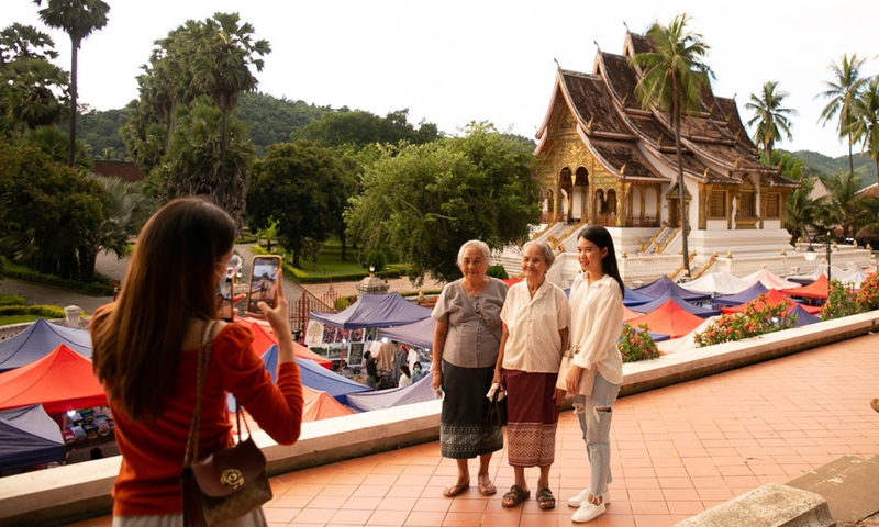Tourists pose for photos in the town of Luang Prabang, a UNESCO world heritage site in Laos, July 15, 2022.(Photo: Xinhua)
