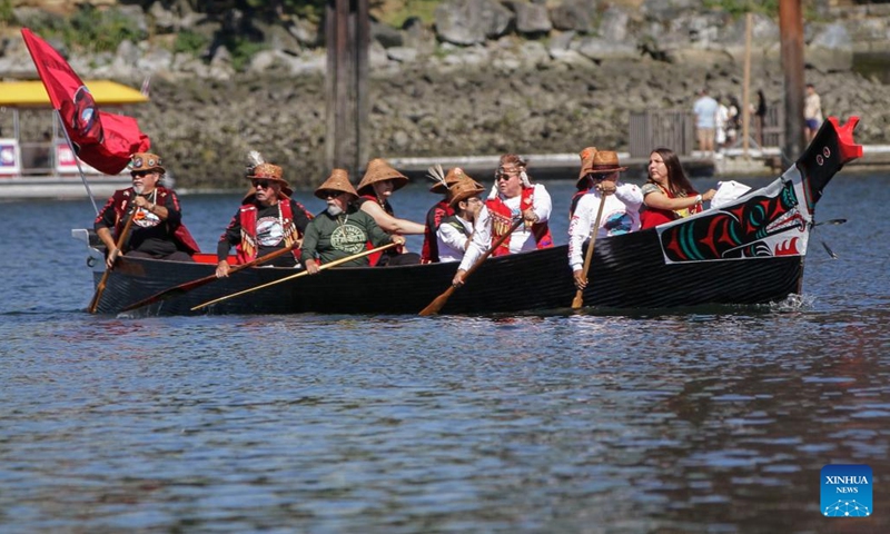 Indigenous people paddle during a canoe arrival ceremony at False Creek in Vancouver, British Columbia, Canada, on July 14, 2022. Indigenous people participated in the canoe arrival ceremony on Thursday to mark the opening of the Sacred Journey exhibition at Science World in Vancouver. The Sacred Journey is an exhibition showcasing Northwest Coast canoe cultures and the indigenous people's way of life.(Photo: Xinhua)