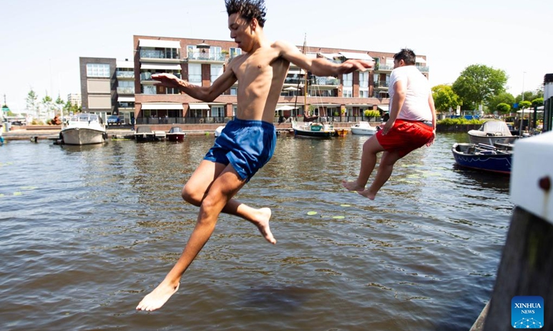 Teenagers jump into the water during a heatwave in Haarlem, the Netherlands, on July 19, 2022. The heatwave swept across the Netherlands on Tuesday, one of the hottest days since the Dutch measurements started in 1901.(Photo: Xinhua)