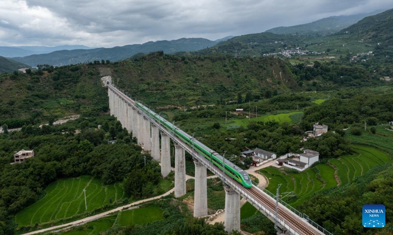 In this aerial photo, a bullet train runs for trial on a bridge along the Dali-Baoshan section of Dali-Ruili Railway in southwest China's Yunnan Province, July 19, 2022. The Dali-Baoshan section of Dali-Ruili Railway will soon be put into operation, putting an end to Baoshan's status as a place with no rail links.(Photo: Xinhua)