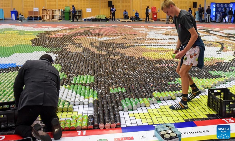 People use food cans to lay out a mosaic in the shape of Nelson Mandela's portrait to mark International Nelson Mandela Day in Cape Town, South Africa, on July 18, 2022.(Photo: Xinhua)