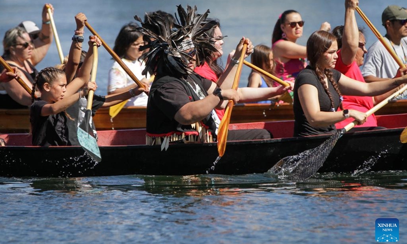 Indigenous people paddle during a canoe arrival ceremony at False Creek in Vancouver, British Columbia, Canada, on July 14, 2022. Indigenous people participated in the canoe arrival ceremony on Thursday to mark the opening of the Sacred Journey exhibition at Science World in Vancouver. The Sacred Journey is an exhibition showcasing Northwest Coast canoe cultures and the indigenous people's way of life. (Photo: Xinhua)