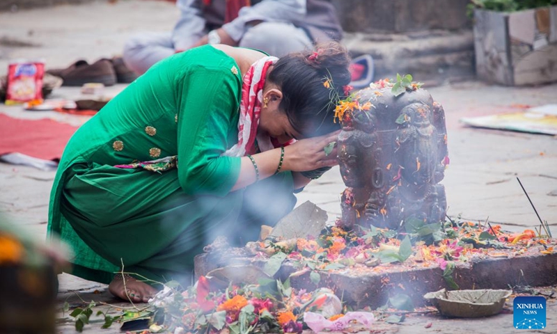 A devotee worships Lord Shiva by presenting offerings during the first Monday of the holy month of Shrawan in Lalitpur, Nepal, July 18, 2022. The holy month of Shrawan is considered auspicious by Hindus for praying to Lord Shiva for happiness and prosperity.(Photo: Xinhua)