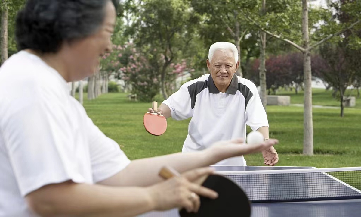 Beijing residents play table tennis in a park Source:VCG