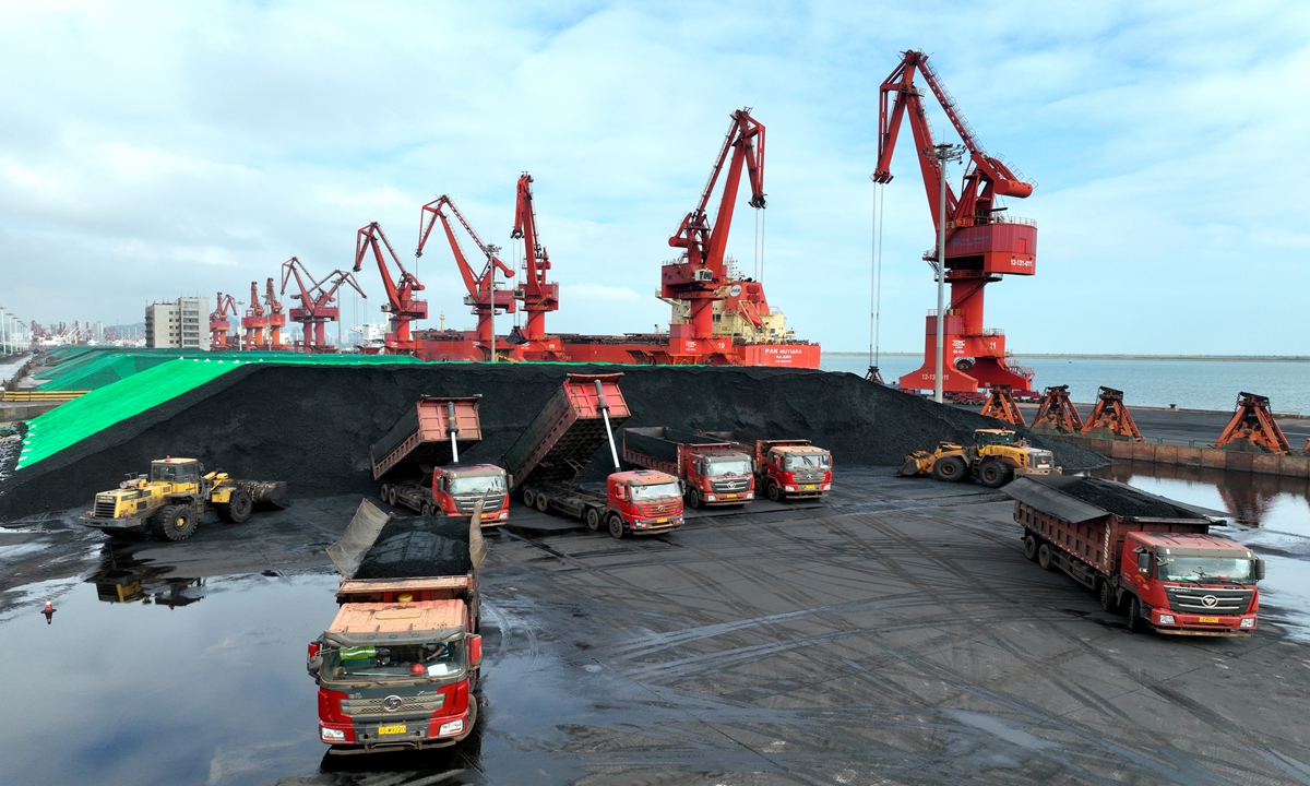 Large machines stack thermal coal on trucks after it's unloaded from a ship at a port in Lianyungang, East China's Jiangsu Province, on July 18, 2022. Lianyungang port has opened a green channel for thermal coal transportation that's open 24/7 in a bid to ensure electricity generation in surrounding power plants. Photo: cnsphoto 