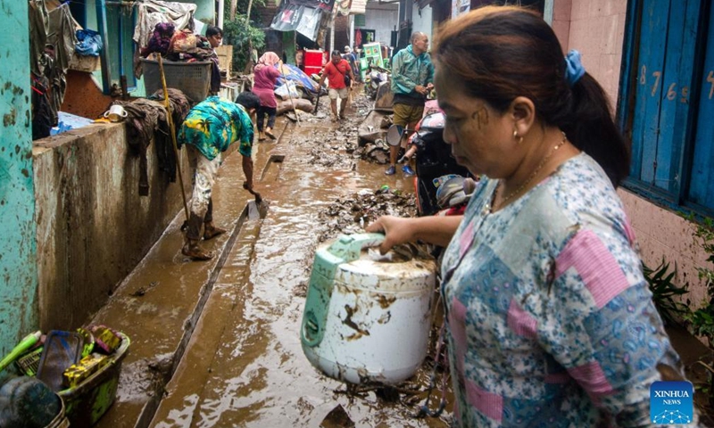 People clean mud from his house after flood in Garut, West Java, Indonesia, July 16, 2022.Photo:Xinhua