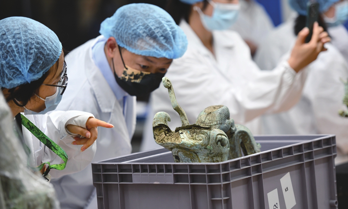 Experts examine a relic from the Sanxingdui Ruins on July 7, 2022. Photo: VCG