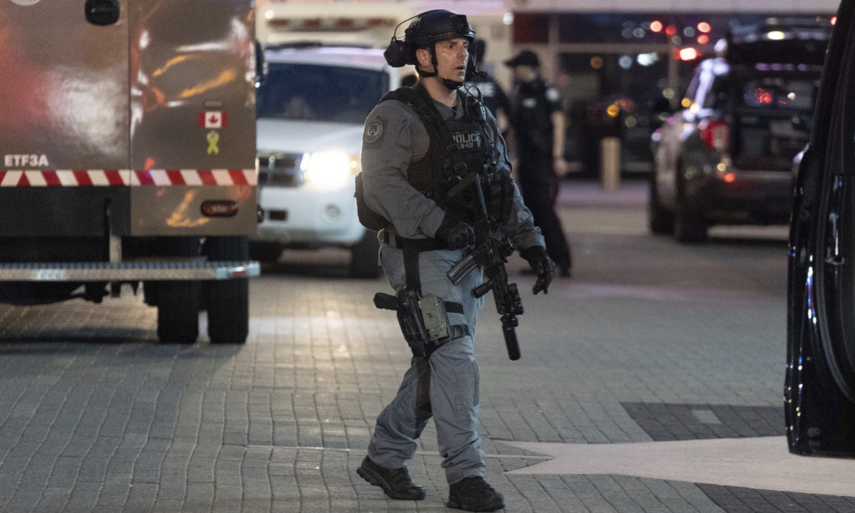 A police officer searches for suspects after a shooting outside Scotiabank Arena, Toronto, Canada, on the night of July 16, 2022. One man was reportedly killed, and police are searching for two suspects. Photo: Xinhua